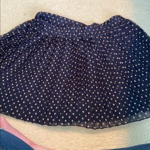 Pleated navy polka dot skirt.